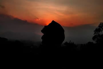 silhouette of person against sunset sky